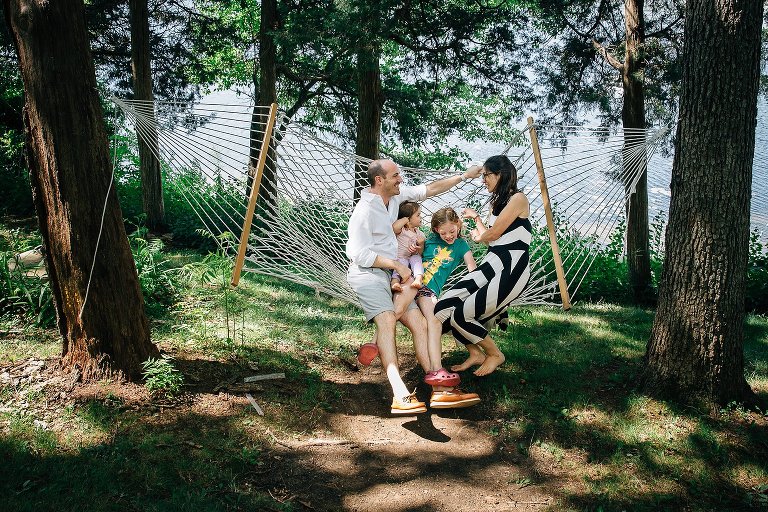 Family swings on hammock together. 