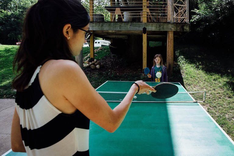Mom and daughter play ping pong. 