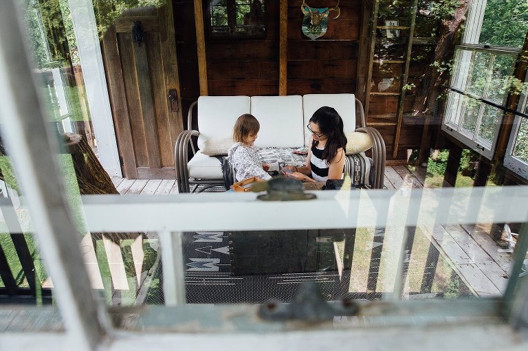 Mom and daughter are together in a tree house. 