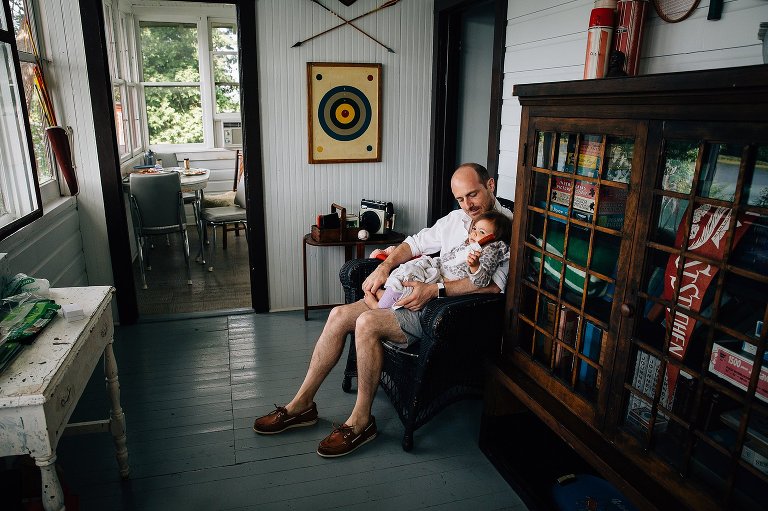 Dad and daughter rest in a vintage summer cabin. 