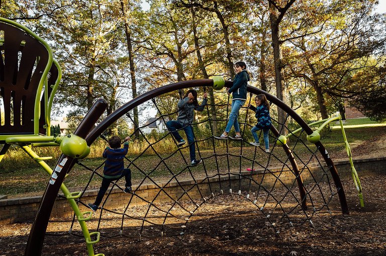 4 kids play on a webbed piece of playground equipment.