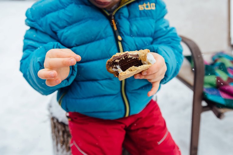 Girl holds a s'more in her hands. 