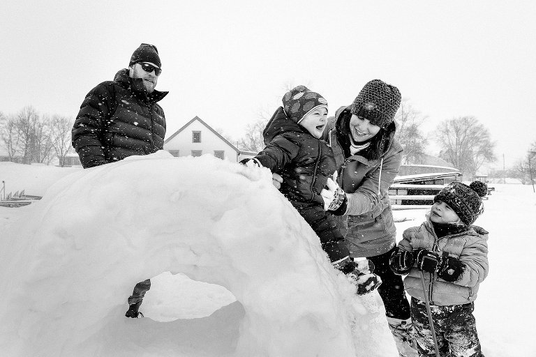 Family plays on a snow "donut" on a snowy day.