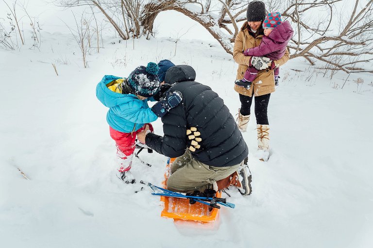 Dad helps daughter out of skis. winter wonderland day pics