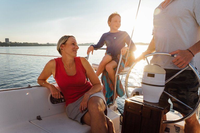 Mom and son on sailbaot with sunset behind them.
