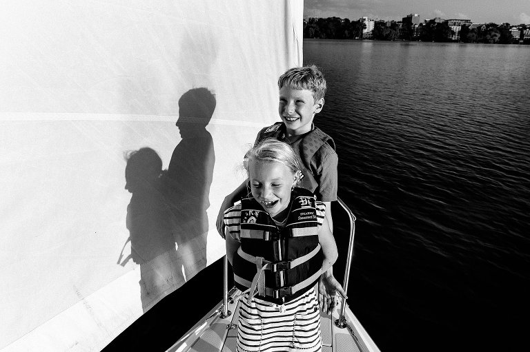 Boy and girl smiling on the sailboat. Profile shadows cast on the sail.