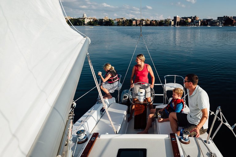Family on a sailboat in the middle of the lake. Sunny day.
