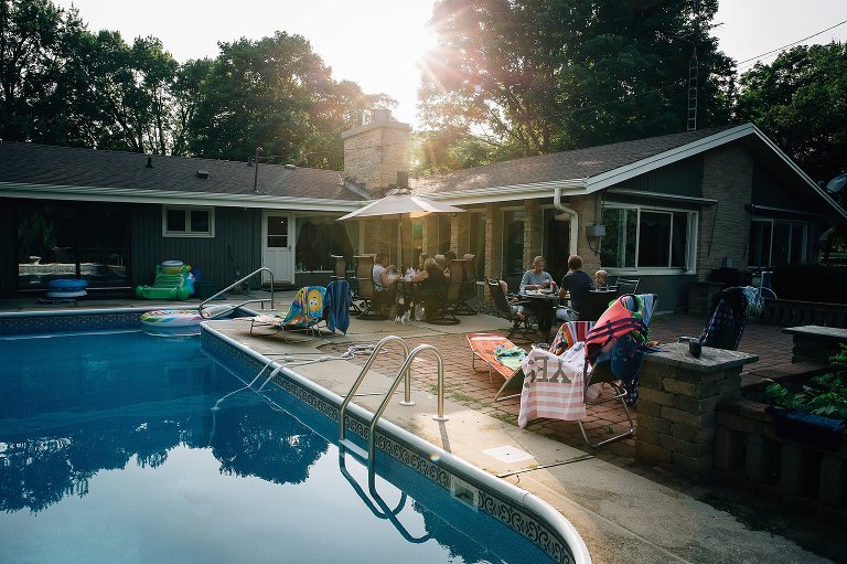 Sunflare lights the backyard full of family hving dinner together. 