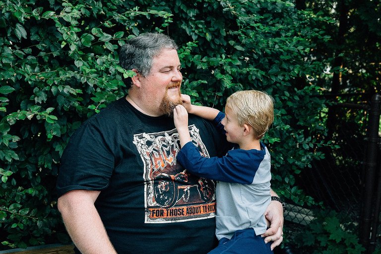 young boy plays with uncles beard