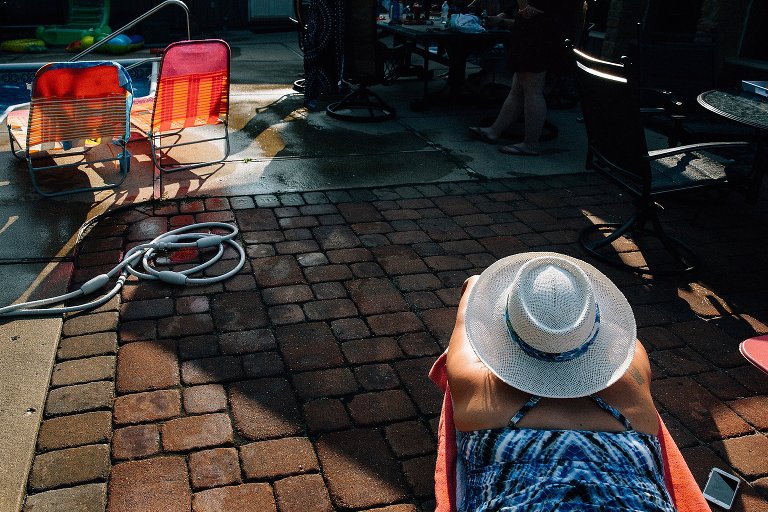 Woman in hat lays in the late afternoon sun. 