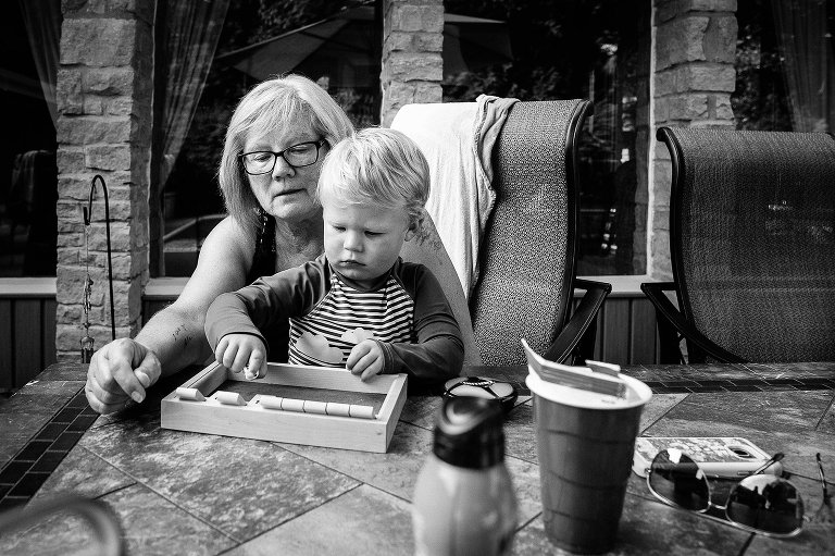 Black and white. Grandma and grandson play Shut The Box game. 