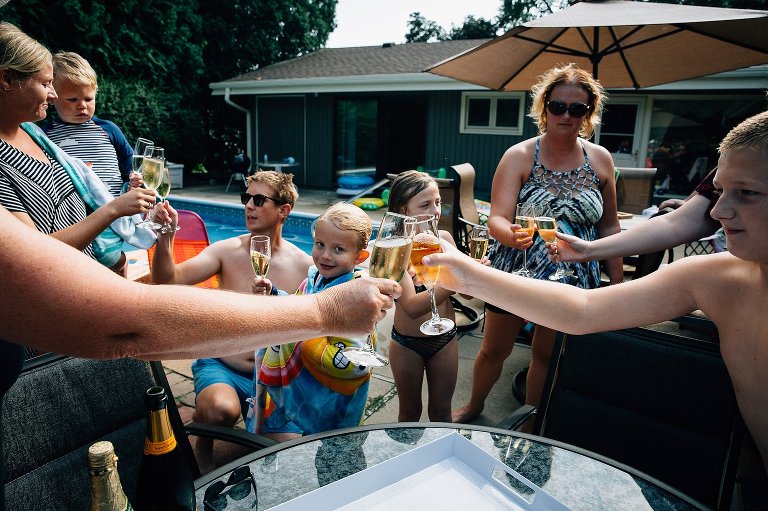 Focus on two glasses of champagne clinking while the rest of the family watches. 