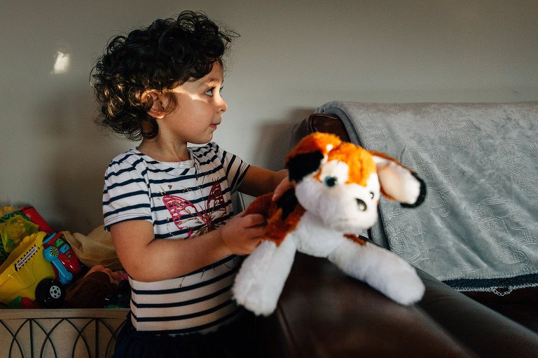 Girl holds special stuffed animal while looking off to the side