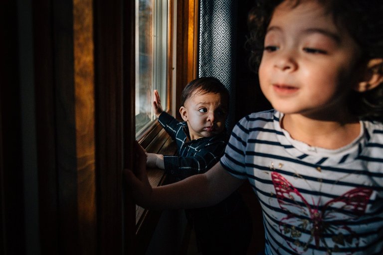 One year old boy in the background is focus while young girl in foreground is out of focus. 