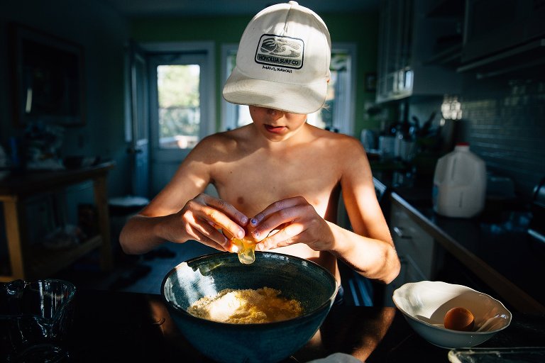 boy cracks egg over a bowl