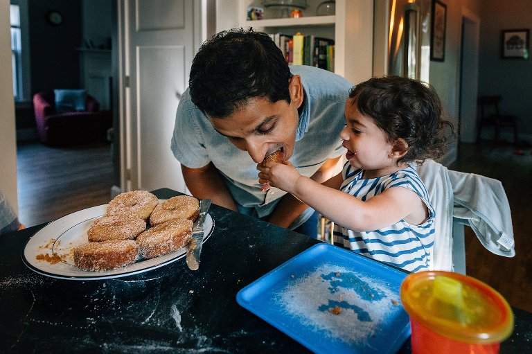 Daughter shares a bite of her apple cider donuts with her dad 
