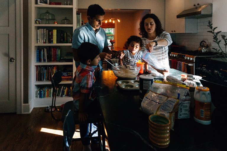 Family of 4 works together making donuts in the kitchen during a Madison family photographer session