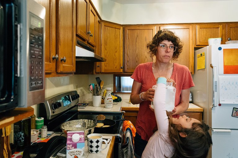 mom waits as daughter reaches into coconut oil container