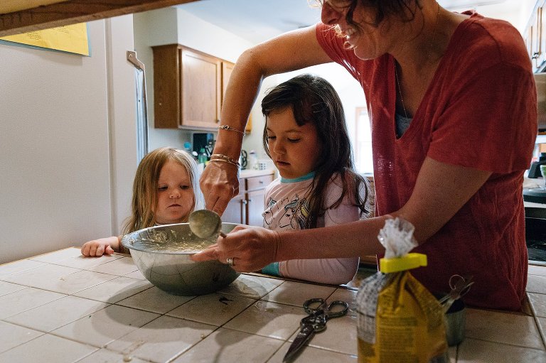Mom and two daughters make pancakes on a spring Saturday morning 