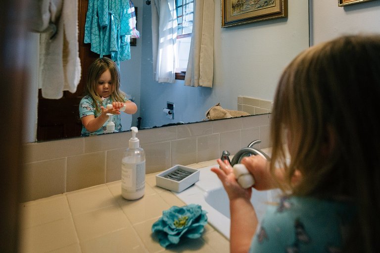 Girl uses bar soap in the bathroom to wash her hands 