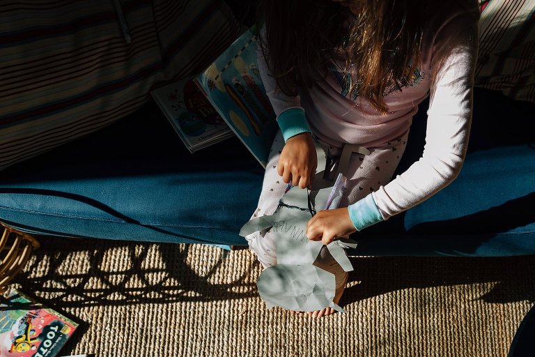 Girl ties a school project doll 