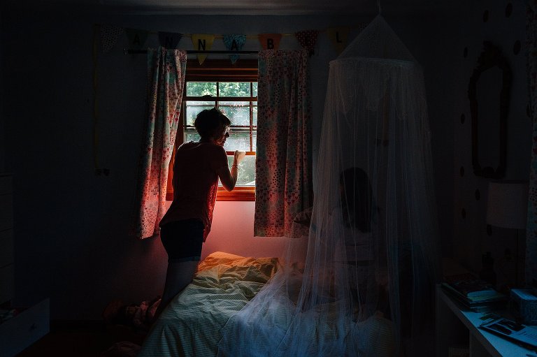 mother opens bedroom window on a spring Saturday