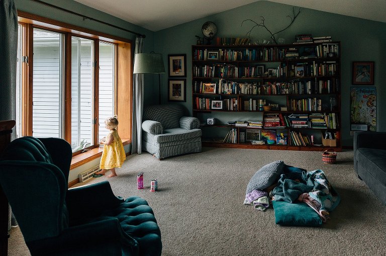 Small girl in yellow dress in big room with books