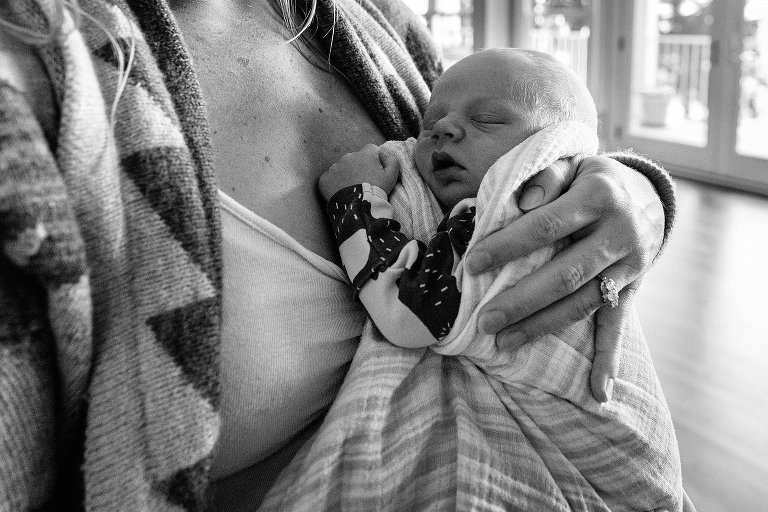 black and white Mom holds sleeping newborn 