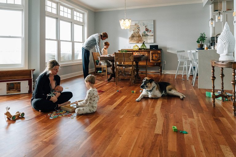 family of 5 and dog play in the living room together 