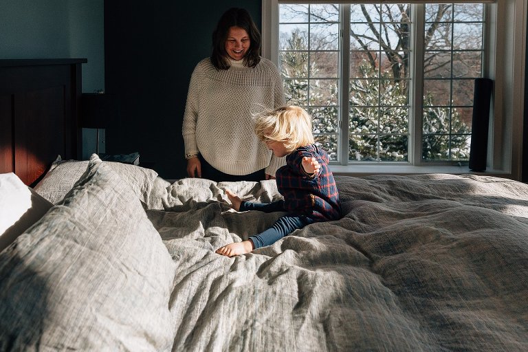 Girl bounces on the bed in sunlight 