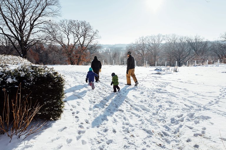 Family of 4 walks in the snow. 