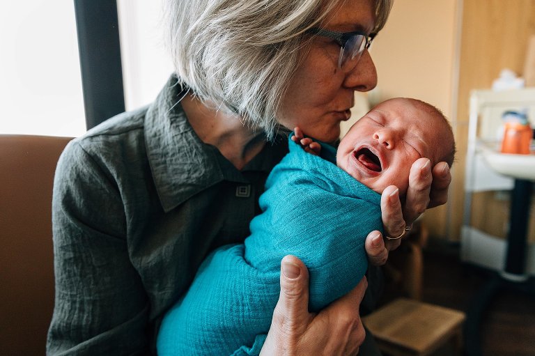 Grandma shushes crying newborn in a hospital photo