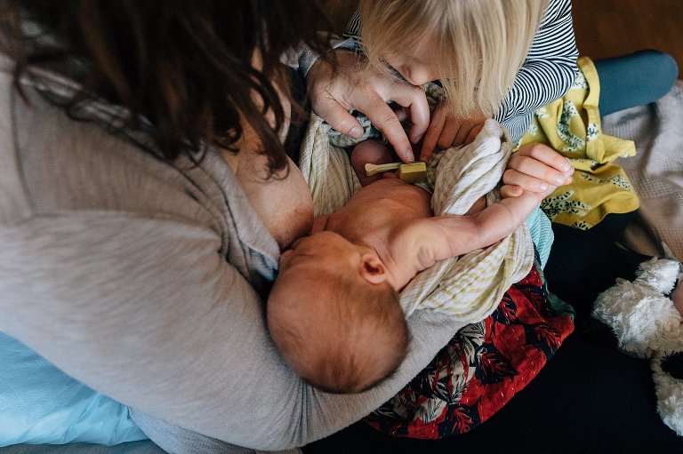 Sister checks out newborn umbilical cord. 