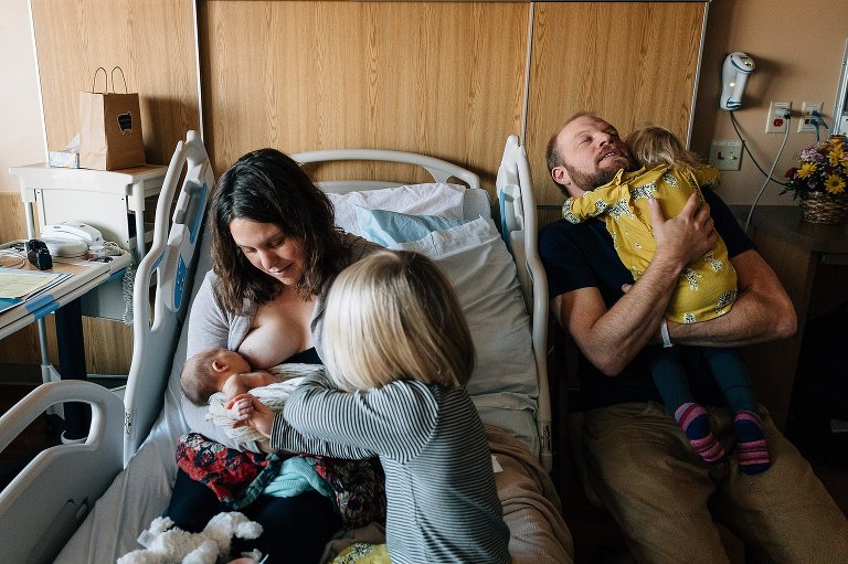 Family of 5 sits in a hospital room after newborn arrives. newborn photo 