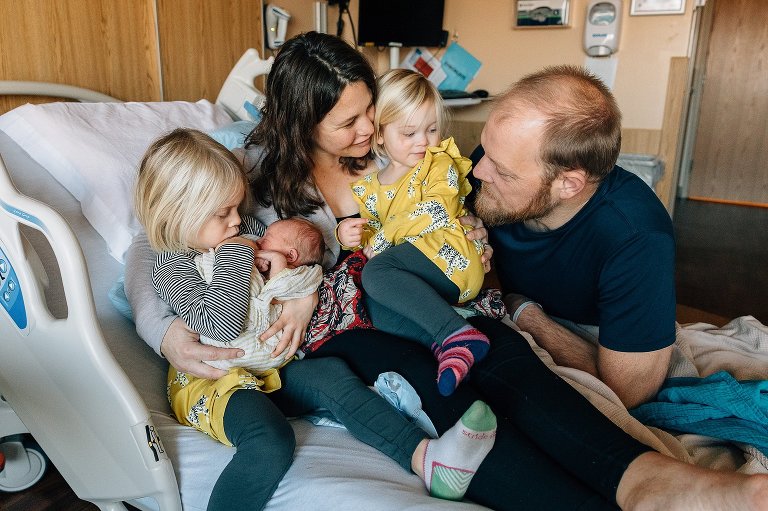 Family of five on a hospital bed after baby born. newborn photo