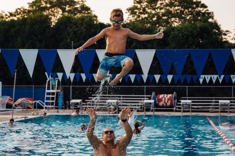 Boy gets tossed in air at swimming pool by his dad. Gift certificates for summer sessions available..