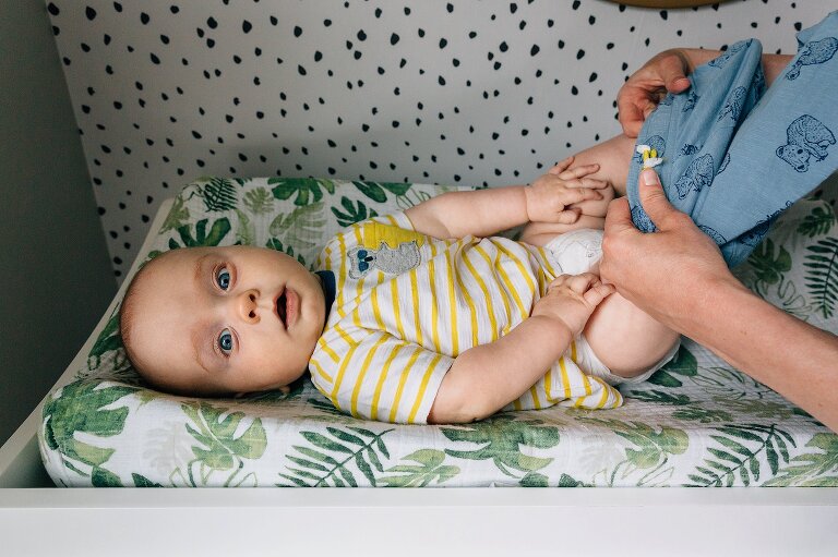 Baby gets a change of clothes on the changing table in nursery