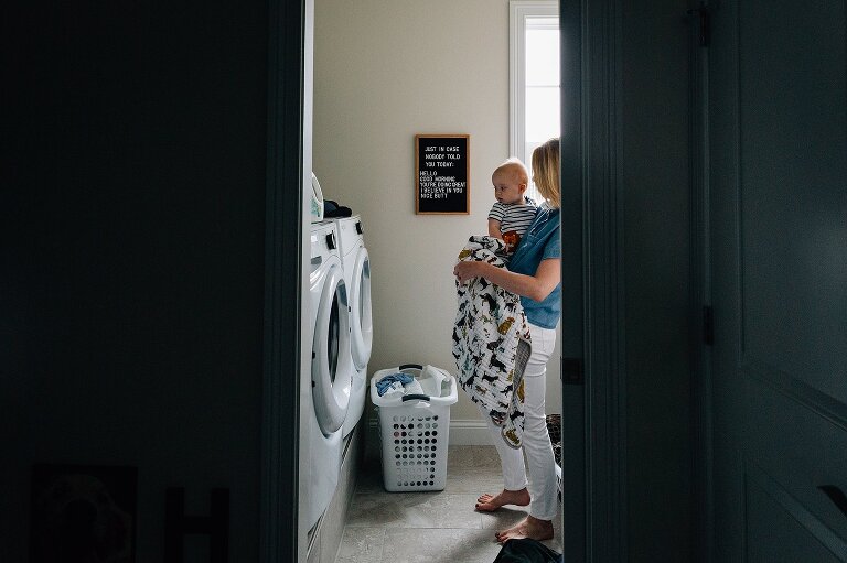 Mom gets fresh blanket out of the dryer during a family photography session in MIddleton