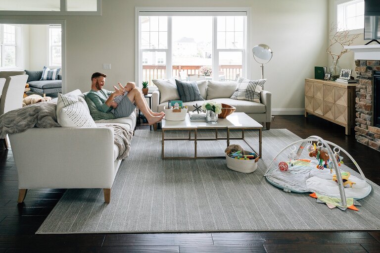 Dad and baby play together in beautiful living room space. Family Photography in MIddleton.