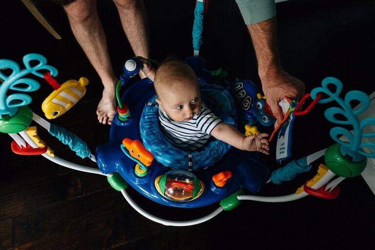 Dad helps hold part of toy for baby during a Family Photography in MIddleton