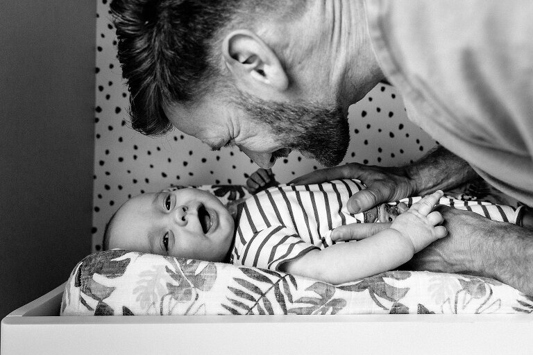dad makes baby smile