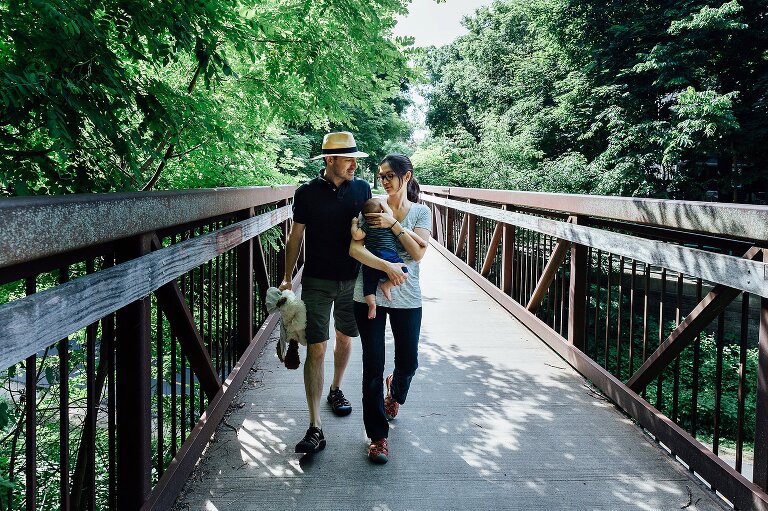Dad, Mom and baby walk across a bridge.