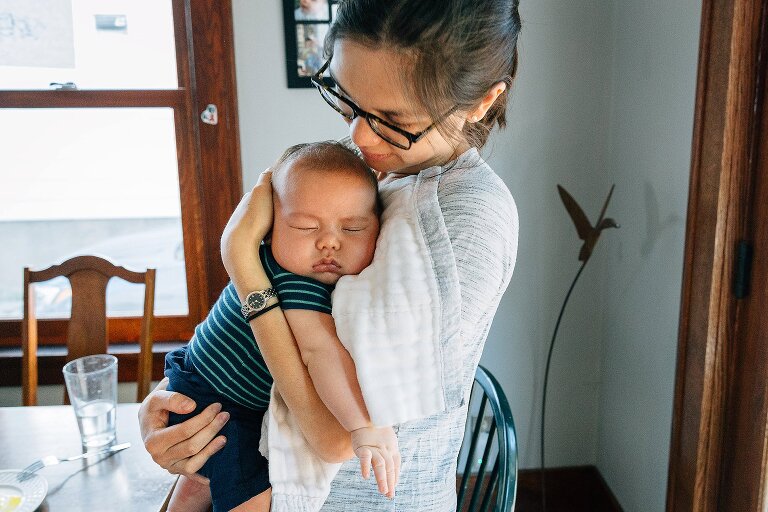 Mother holds sleeping infant in her arms