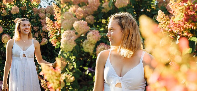 high school senior near blooming hydrangea bush in Arb