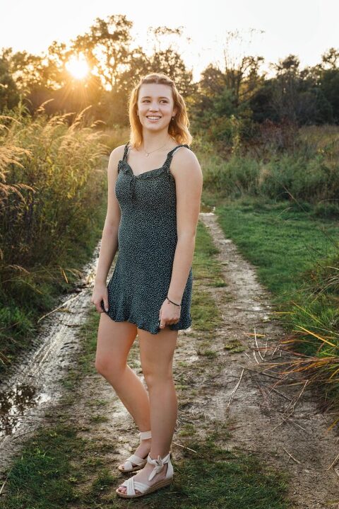 Setting sun behind high school senior in the Arb for yearbook photos