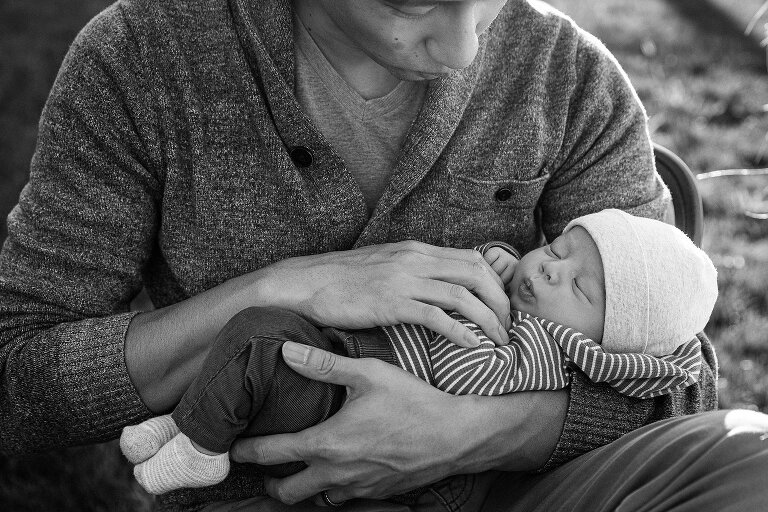 Newborn purses lips in his sleep and Dad mimics his expression