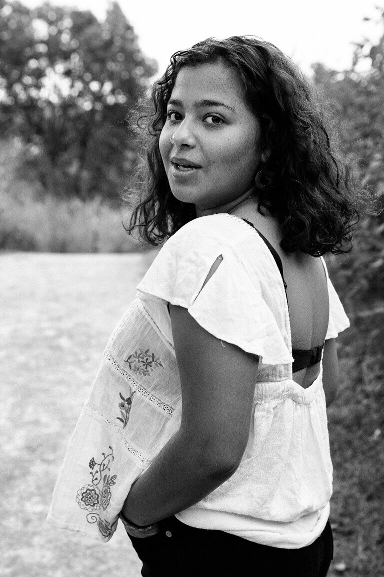 Black and white. High school girl senior looks over her shoulder