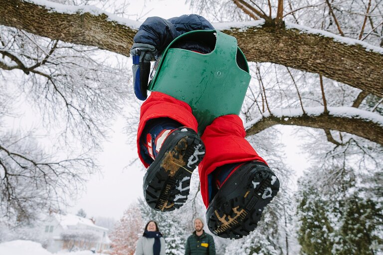View from toddler's boots on a swing with mom and dad in the background. 