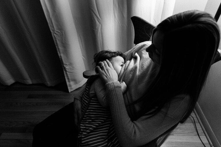 Black and white. Mother breastfeeds infant. 