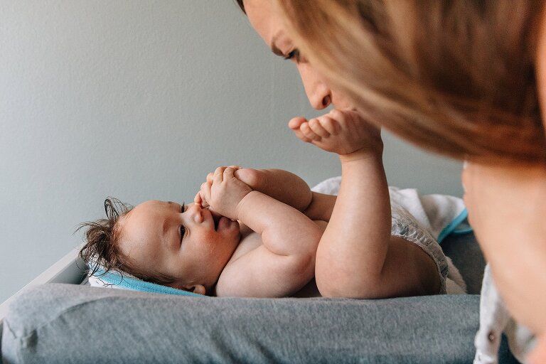 Mother plays with infant. 